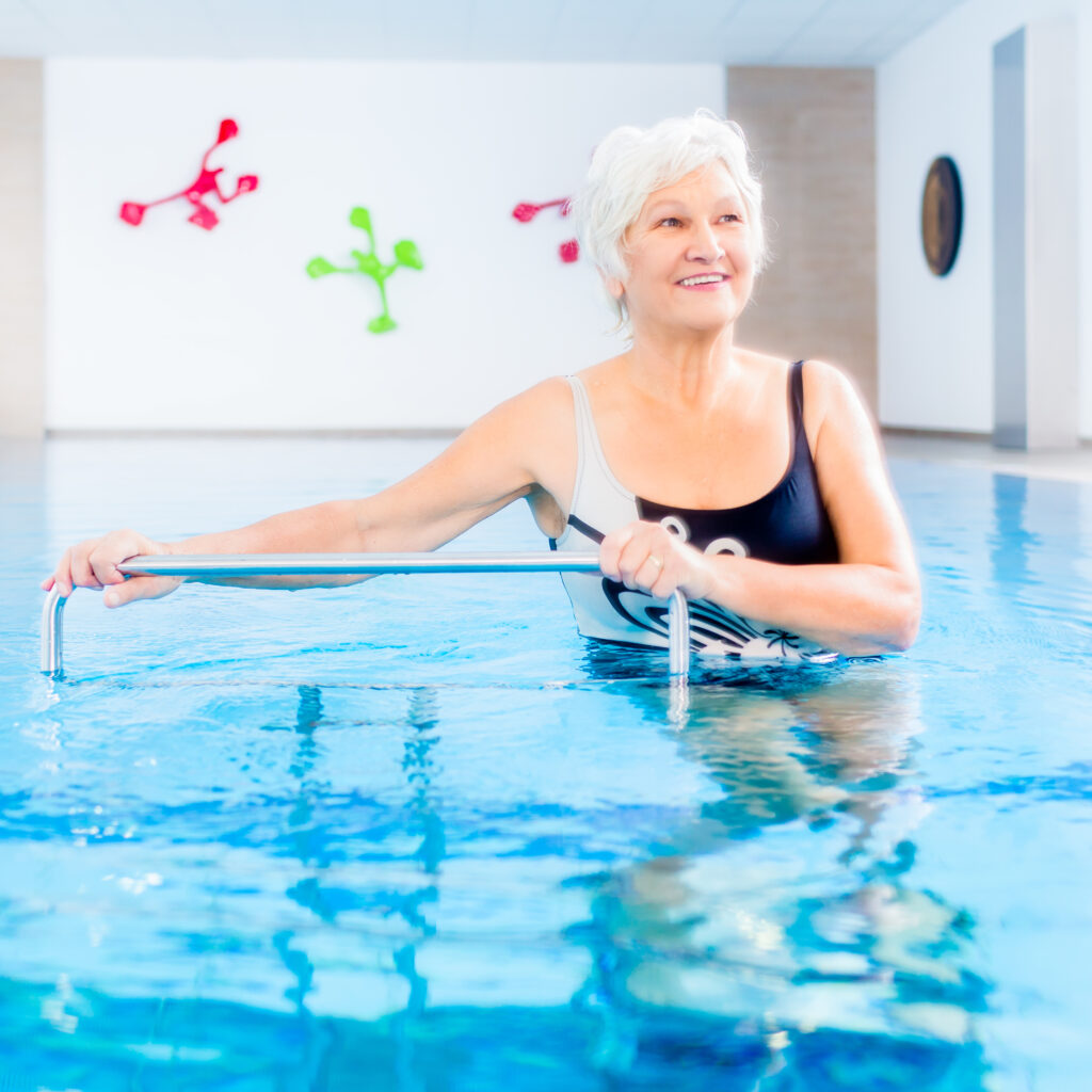 Senior woman in underwater gymnastics therapy with sliding machine